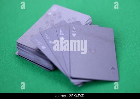 Black playing cards with aces lie on green gaming table Stock Photo