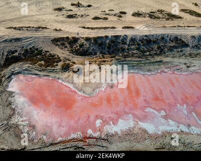 Pink lake in Ras al Khaimah surrounded by seaside and creek water, desert sand dues and mountains mountains in the United Arab Emirates offering uniqu