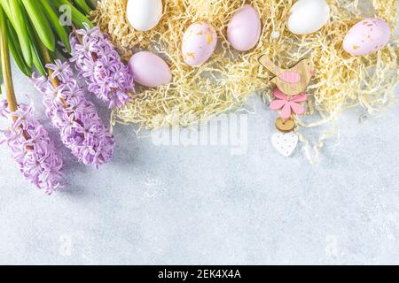 Easter greeting card with colored pink eggs and hyacinths over light gray concrete surface background. Happy Easter festive background Stock Photo