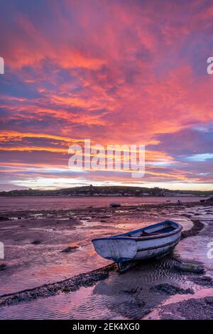 Appledore, North Devon, England. Tuesday 23rd February 2021. UK Weather. At dawn, a strong breeze scatters the clouds as the sun rises over the River Torridge estuary at low tide, in the picturesque coastal villages of Appledore and Instow. Credit: Terry Mathews/Alamy Live News Stock Photo