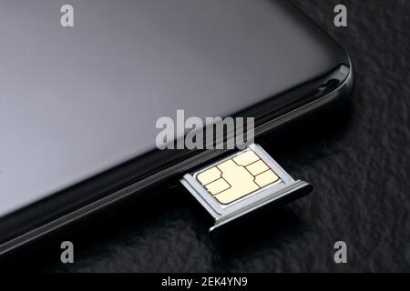 Close up of a cell phone with sim card on black background. Stock Photo