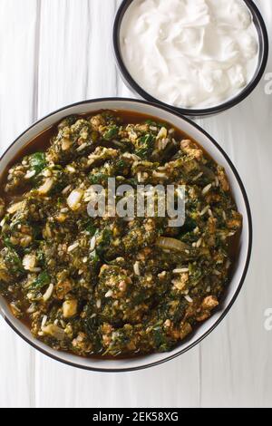 Kiymali Ispanak Spinach with ground meat, onions and rice closeup in the bowl on the table. Vertical top view from above Stock Photo