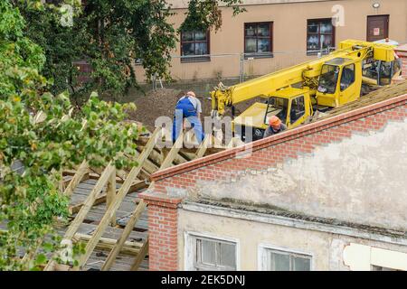 Workers roofers builders working on roof structure on construction site, Kuldiga, Latvia Stock Photo