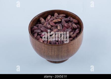 A small wooden bowl full of raw red kidney beans Stock Photo