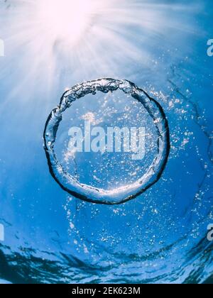 Ring air bubble underwater and sun light in transparent ocean. Water texture. Stock Photo