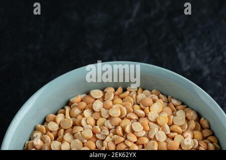 A blue plate with uncooked popcorn on a dark background Stock Photo
