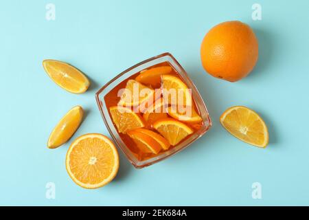 Bowl of orange jelly with orange slices on blue background Stock Photo