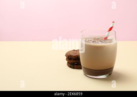 Glass of chocolate milkshake and cookies on beige table Stock Photo