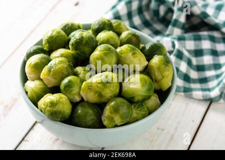 Set of brussel sprouts in a bowl on white wooden table Stock Photo