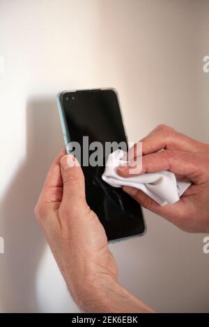 Man Cleaning Mobile Phone with Cloth Stock Photo