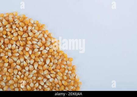 Heap of uncooked corn grains on a white background Stock Photo