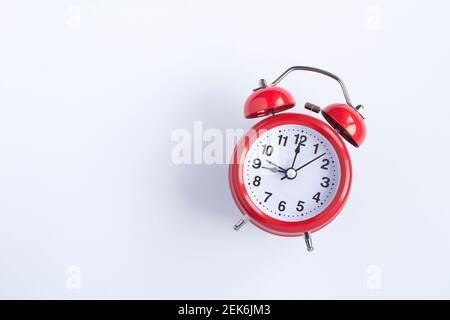 Red alarm clock on the white  background.  Top view. Copy space. Closeup. Stock Photo