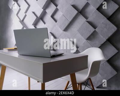 Empty creative workplace. Table with laptop and papers and chair. Empty office. Stock Photo