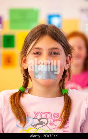 Young child with their mouth taped up in a school classroom Stock Photo ...