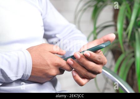 man sitting on a chair using smart phone  Stock Photo