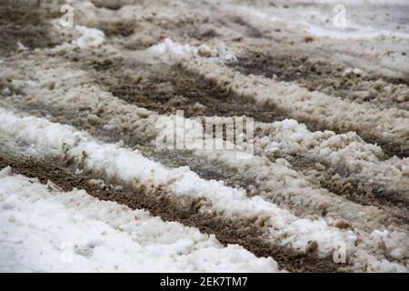 Dirty snow mixed with clean on the road. Snow melt with sand on it. Stock Photo