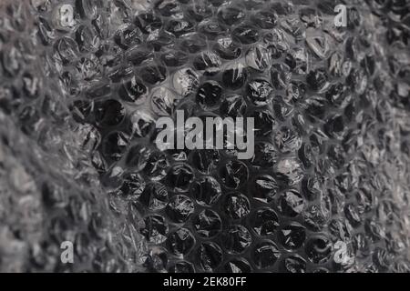 crumpled dark air bubble wrap - real life close-up background with selective focus Stock Photo