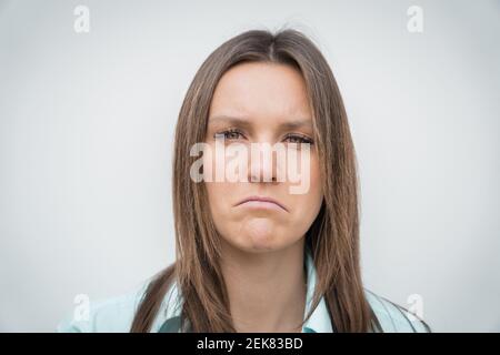 Sad unhappy and disappointed woman face. Young woman frowning face. Facial expression of feeling sadness. Stock Photo