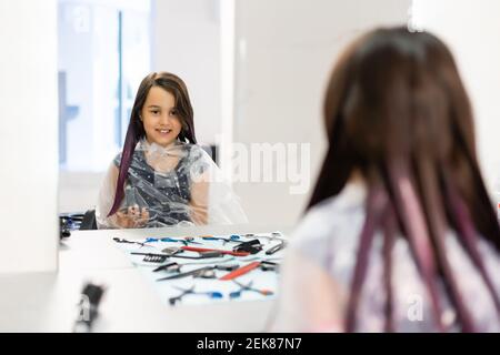 little girl dyes her hair purple in a hairdressing salon Stock Photo