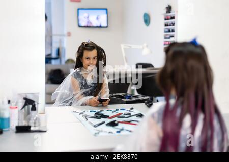 little girl dyes her hair purple in a hairdressing salon Stock Photo