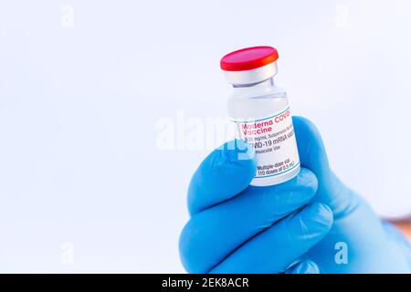 Brasov, Romania - February 21, 2021: Doctor or scientist holding Moderna Covid-19 vaccine on a white background. Stock Photo
