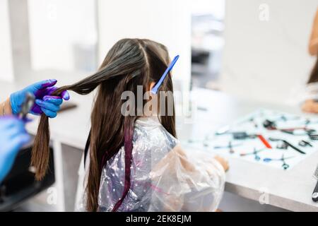 little girl dyes her hair purple in a hairdressing salon Stock Photo