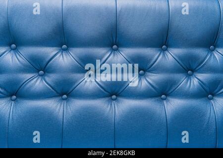 Blue leather upholstery sofa with pattern button design furniture style decor texture background. Stock Photo