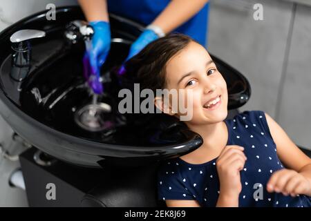 little girl dyes her hair purple in a hairdressing salon Stock Photo