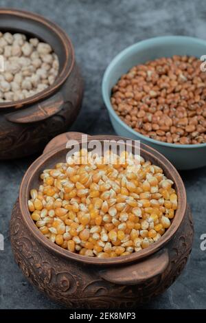 Different kinds of bean seeds, lentil, peas in dishes on a dark background Stock Photo