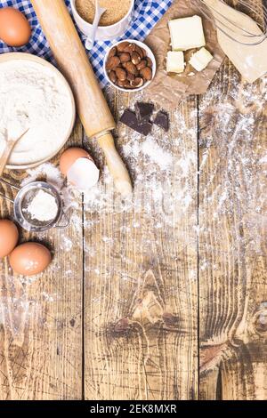 Frame of baking and cooking pastry or cake with ingredients and utensils. Flour, sugar, eggs, butter and almonds on rustic wooden background with copy Stock Photo