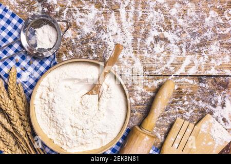 Frame of baking and cooking pastry or cake with ingredients and utensils. Flour and wheat on rustic wooden background with copy space for text, flat l Stock Photo