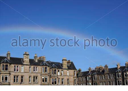 Edinburgh, Scotland, UK. 23rd Feb 2021. A temporary break in the midday cloud and showers give rise to  a rainbow over residential city centre rooftops.  Credit: Craig Brown/Alamy Live News Stock Photo