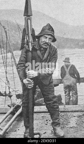 Early 20th century photo of man holding an explosive whaling harpoon from a harpoon gun or canon in Newfoundland Canada. Stock Photo