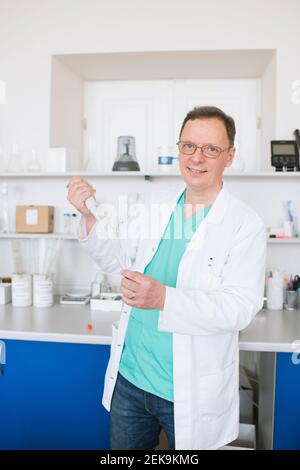 Portrait of researcher in white coat working in lab Stock Photo