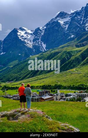 Italy, Valtournenche, Man and woman admiring landscape surrounding Breuil-Cervinia resort in spring Stock Photo