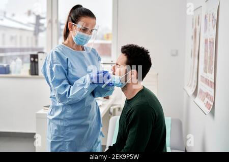 Female doctor collecting sample for COVID-19 test Stock Photo