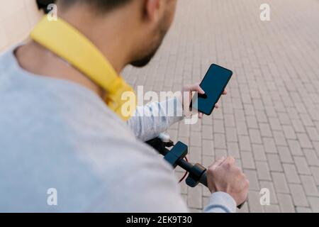 Young man with electric push scooter using smart phone Stock Photo