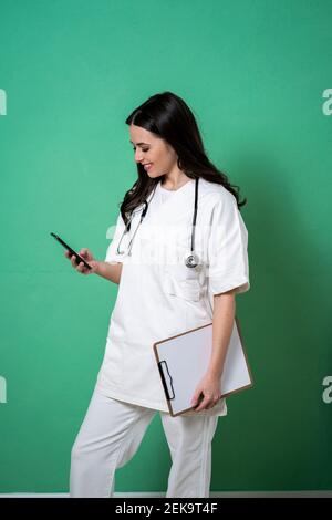 Smiling female doctor using smart phone in studio Stock Photo