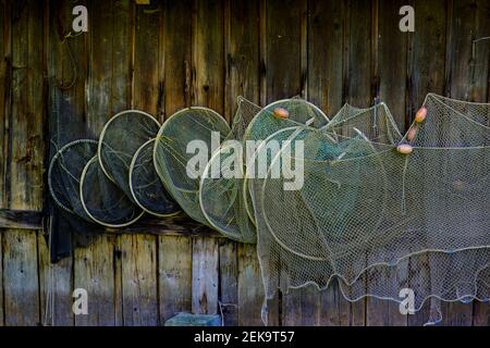 Old fishing nets with glass floats hanging at a boathouse wall in