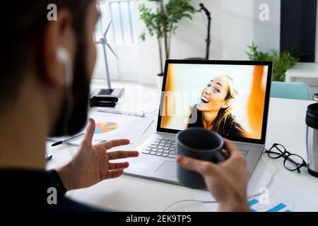 Young businessman having video call via laptop in creative office Stock Photo
