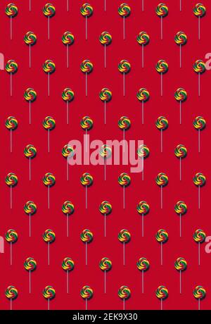 Pattern of multi colored lollipops against red background Stock Photo