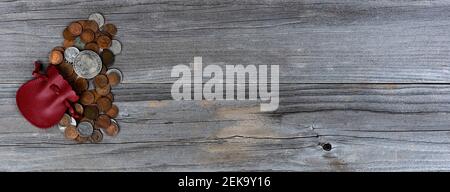 Vintage coins with leather pouch on weathered wooden planks Stock Photo