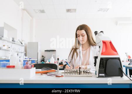 Young researcher in white coat working in a lab Stock Photo