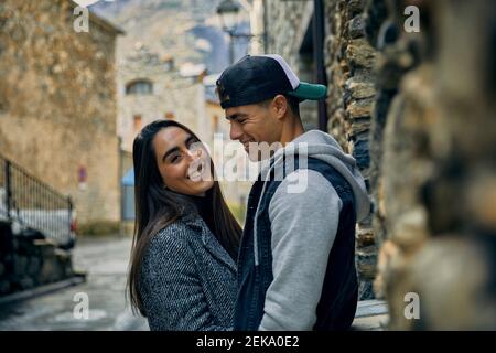 Smiling young man looking at girlfriend while standing in town Stock Photo