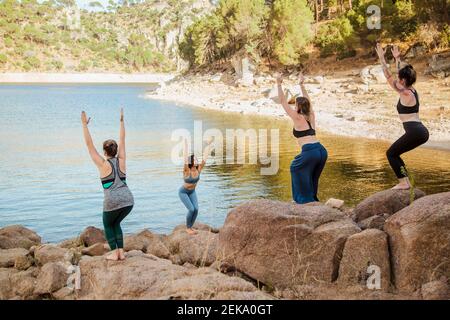 Female yoga instructor teaching chair pose to young women Stock Photo