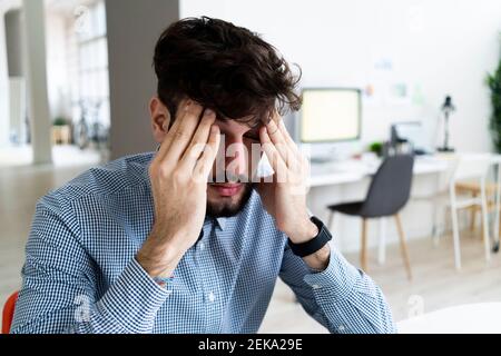 Tired businessman sitting in office Stock Photo
