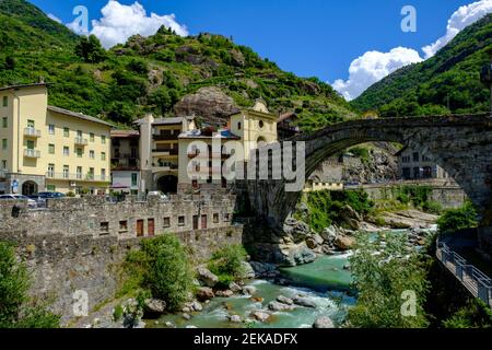 Italy, Pont-Saint-Martin, Town in Aosta Valley with Roman arch bridge stretching over river Lys in foreground Stock Photo