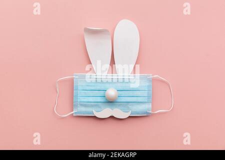 Coronavirus Easter bunny face made from rabbit ears and a protective face mask Stock Photo