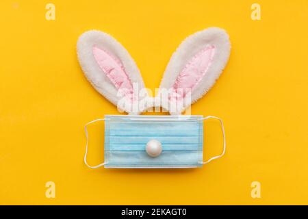 Coronavirus Easter bunny face made from rabbit ears and a protective face mask Stock Photo