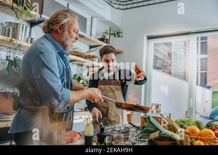 Chef team preparing food while standing in kitchen Stock Photo